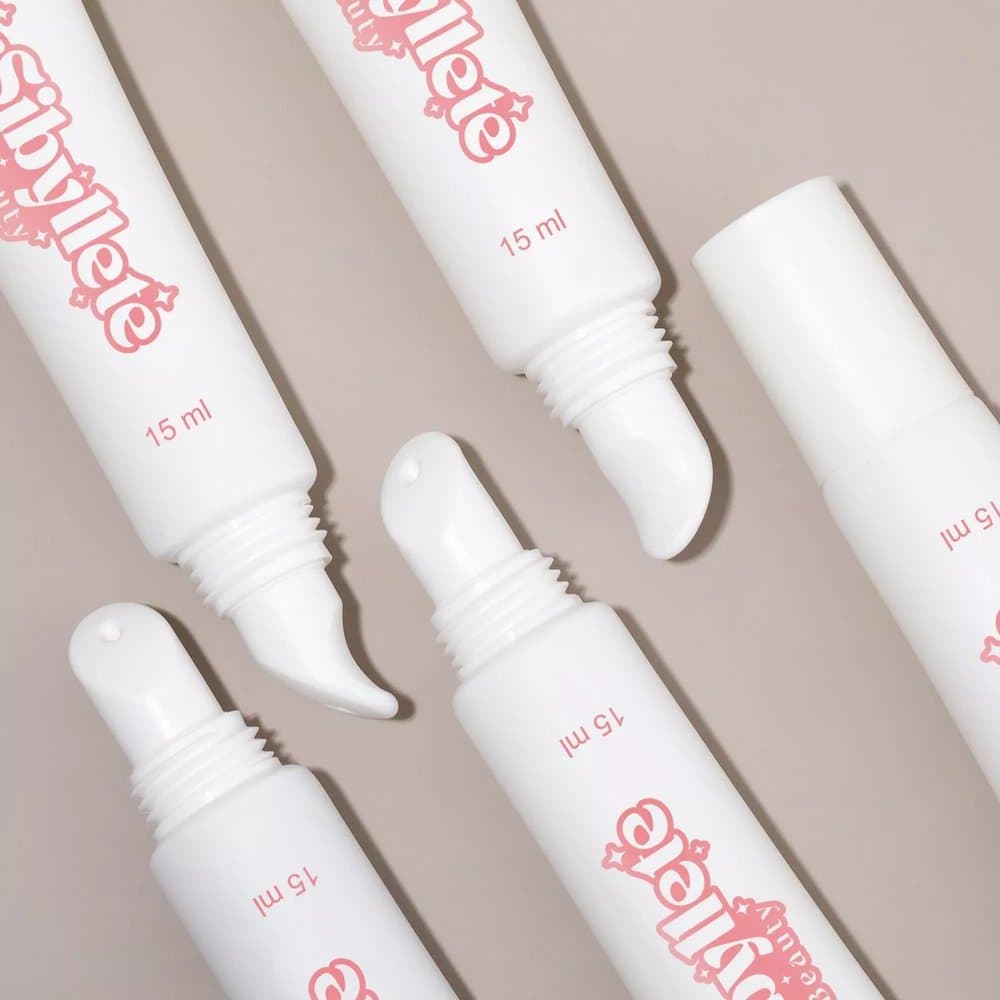 Composition vue de dessus montrant plusieurs tubes de 15ml du Baume à Lèvres Réparateur By Sibyllete avec leur embout applicateur biseauté.