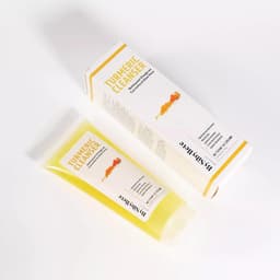 Vue en plongée du tube transparent de Nettoyant Visage au Curcuma et Aloe Vera By Sibyllete (120g) et de sa boîte sur fond blanc.